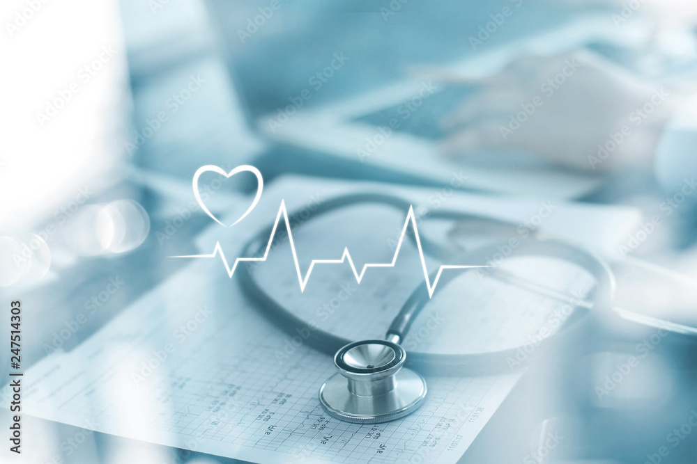 Stethoscope with heart beat report and doctor analyzing checkup on laptop in health medical laboratory background.