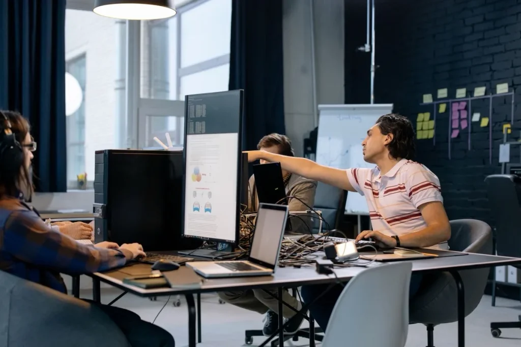 Team working through software development problems at a shared workstation