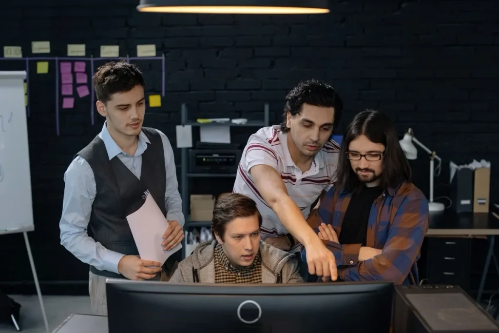 Engineering team reviewing a proposed change together at a workstation