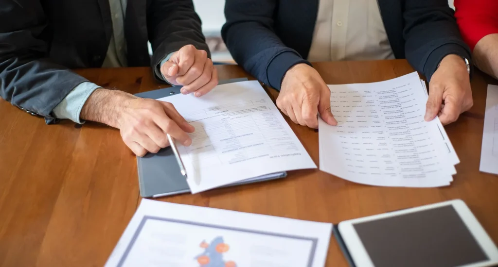 Colleagues reviewing printed documents together at a meeting table