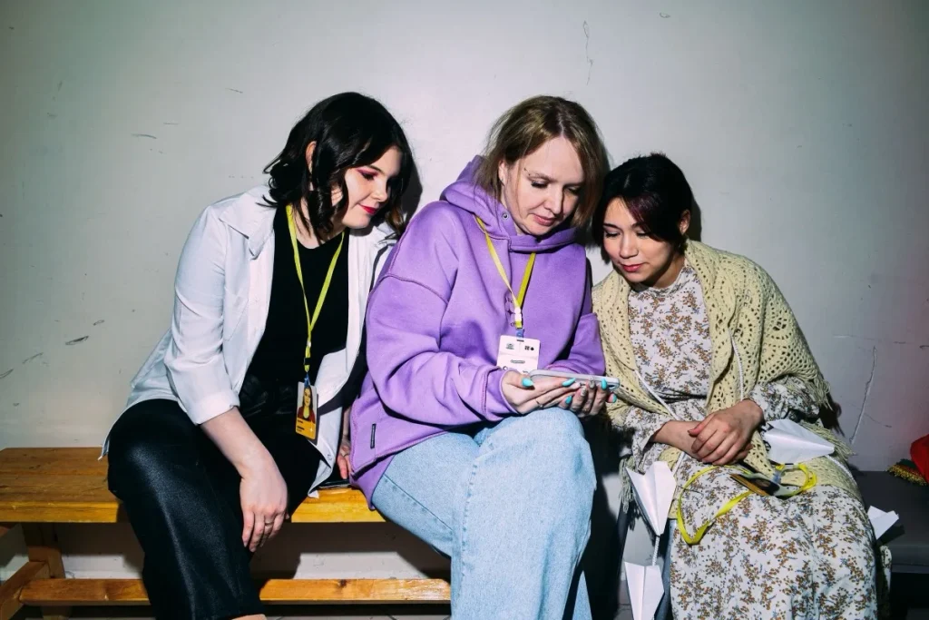 Three young viewers watching content together on a mobile phone