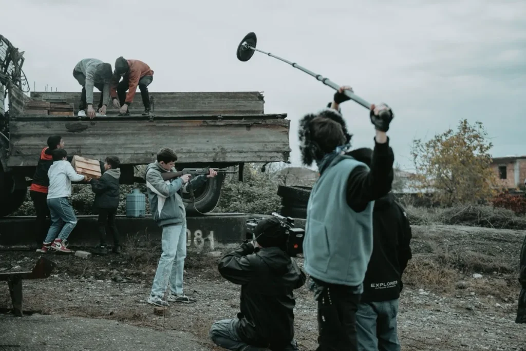 A film crew shooting a drama scene with camera and boom microphone