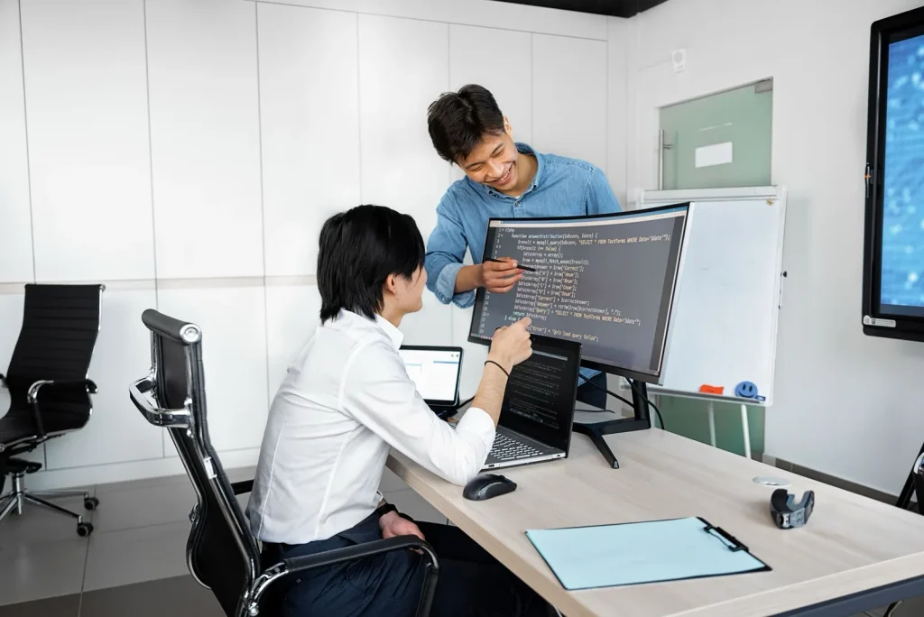 Two engineers reviewing a code change together at a desk